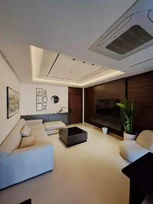 a living room with a couch and a tv at The Boulevard Residences in Amman