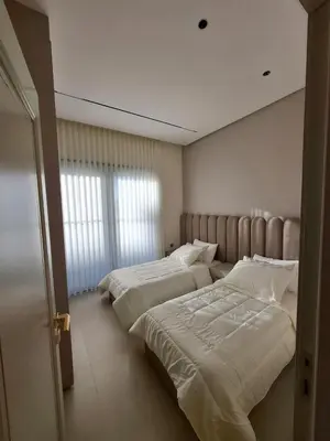 two beds in a hotel room with white sheets at The Boulevard Residences in Amman