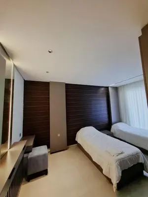 a bedroom with two beds and a desk in it at The Boulevard Residences in Amman
