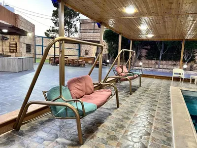 two chairs on a porch next to a swimming pool at مزرعة وشاليه ادم