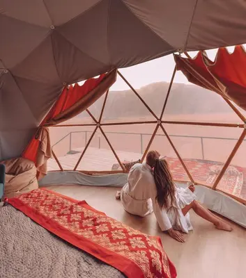 two people laying on the floor in a tent at RUM Bubble lUXURY CAMP in Disah