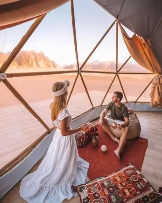 a woman and a man sitting in a tent at RUM Bubble lUXURY CAMP in Disah