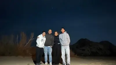 a group of four men posing for a picture at night at RUM Bubble lUXURY CAMP in Disah