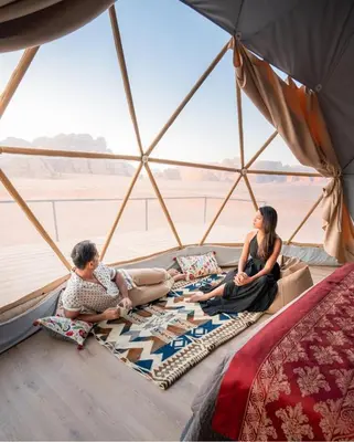 two women sitting on the floor of a yurt at RUM Bubble lUXURY CAMP in Disah