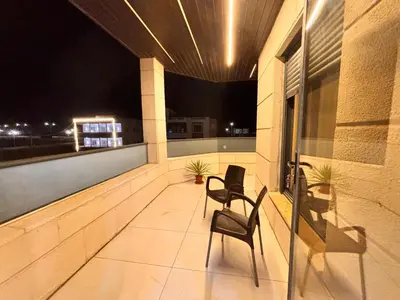 two chairs sitting on a balcony at night at Luxury comfortable apartment