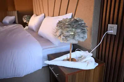 a table with a flower on top of a bed at Suleman Camp in Wadi Rum