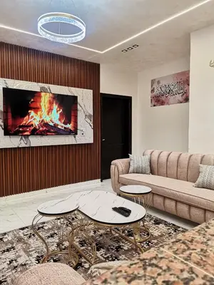 a living room with a couch and a fireplace at دار عدنان للشقق الفندقية المفروشة in Al Mafraq
