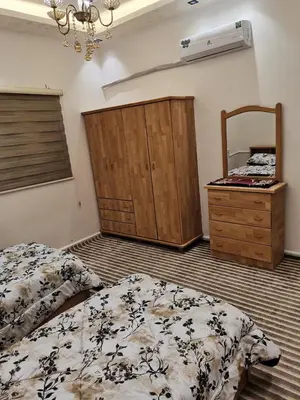a bedroom with two beds and a dresser and a mirror at دار عدنان للشقق الفندقية المفروشة in Al Mafraq