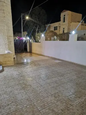 an empty patio at night with a white fence at دار عدنان للشقق الفندقية المفروشة in Al Mafraq