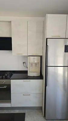 a kitchen with white cabinets and a refrigerator at Villa rooftop with stunning view apartment in Amman