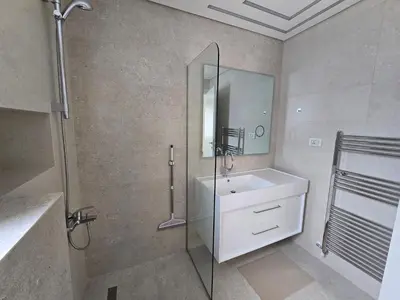 a bathroom with a sink and a shower with a mirror at Villa rooftop with stunning view apartment in Amman