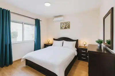 a bedroom with a large bed and a window at The Central Family Apartment in Amman