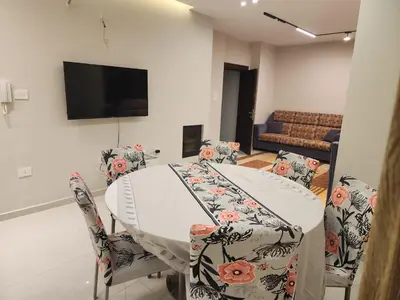 a dining room with a white table and chairs at 3BR Furnished Apartment for Rent - PART OF VILLA in Amman