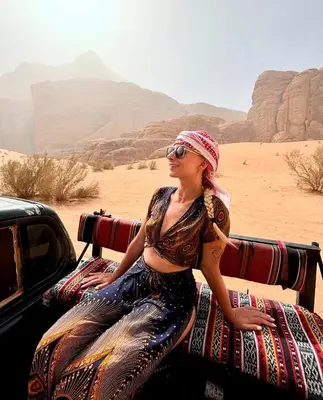 a woman sitting in the back of a truck in the desert at Camp in the natural reserve & tours in Aqaba