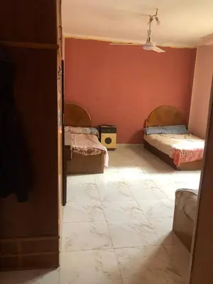 a bedroom with two beds in a room with red walls at Camera inn in Bushrá