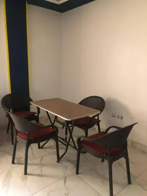 a table and four chairs and a table and chairs at Camera inn in Bushrá