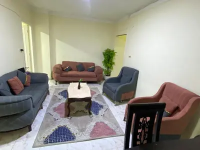 a living room with two couches and a table in a room at Yes inn in Bushrá