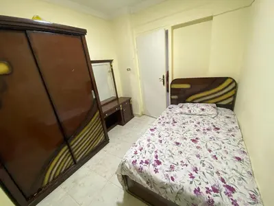 a small bedroom with a bed and a closet at Yes inn in Bushrá