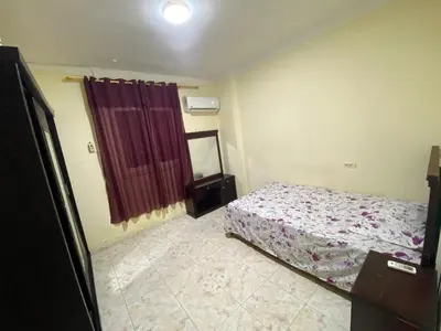 a bedroom with a bed and a red curtain at Yes inn in Bushrá