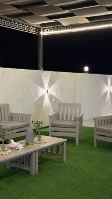 a room with three benches and a table and grass at Olive tree chalet and farm -مزرعه و شاليه شجره الزيتون
