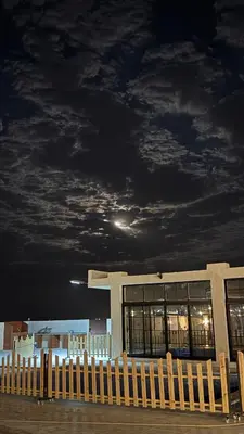 a building with a cloudy sky at night at Olive tree chalet and farm -مزرعه و شاليه شجره الزيتون