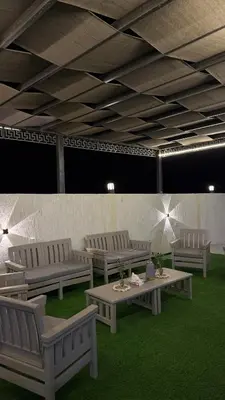 a room with white benches and tables on grass at Olive tree chalet and farm -مزرعه و شاليه شجره الزيتون