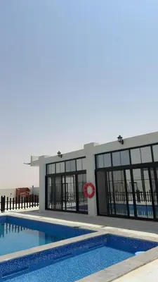 a large building with a swimming pool in front of it at olive tree farm and chalet - مزرعه و شاليه شجره الزيتون