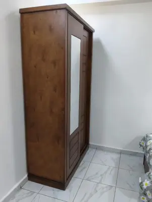 a wooden cabinet with a mirror in a room at Tamri guest house in Amman