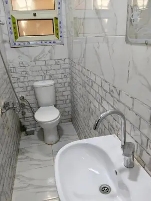 a white bathroom with a toilet and a sink at Tamri guest house in Amman