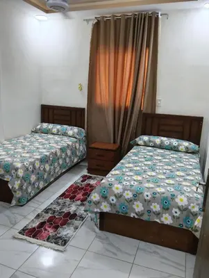 two beds sitting next to each other in a room at Tamri guest house in Amman