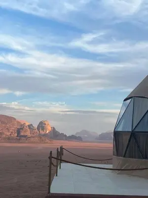 a building in the desert with mountains in the background at Dania Luxury Camp in Wadi Rum