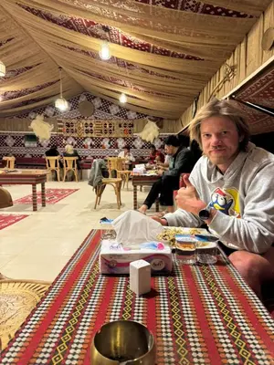a man sitting at a table in a restaurant at Dania Luxury Camp in Wadi Rum