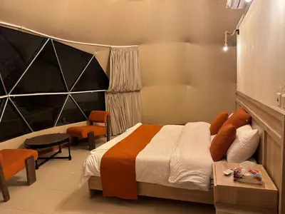 a bedroom with a bed and a table and chairs at Wadi rum Jad luxury camp in Wadi Rum