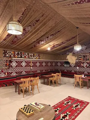 a room with tables and chairs in a room with tiles at Wadi rum Jad luxury camp in Wadi Rum