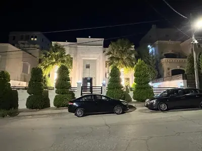 two cars parked in front of a building at night at Luxurious 5 bedroom Furnished Villa superb locationفيلا فخمه in Amman