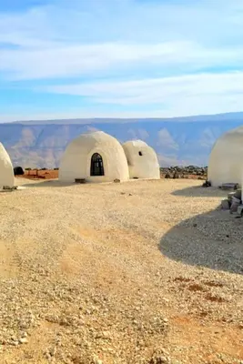 a group of domes in a desert with mountains in the background at Tootya camp