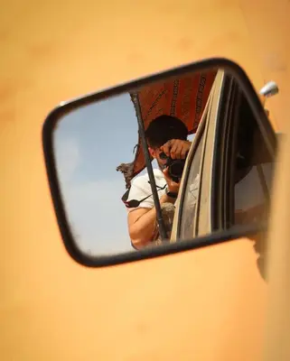 a person taking a picture in a rear view mirror at Wadi rum Bubble Bianca luxury in Wadi Rum