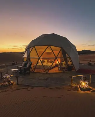 a tent in the desert with two chairs and lights at Wadi rum Bubble Bianca luxury in Wadi Rum