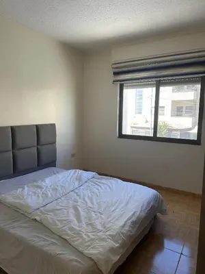 a bedroom with a large bed with a window at الجبيهة 2 نوم aljubiha apartment in Amman