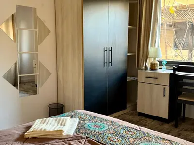 a bedroom with a bed and a cabinet and a desk at Spacious central apartment in Amman