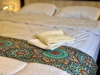 a white bed with two folded towels on it at Spacious central apartment in Amman