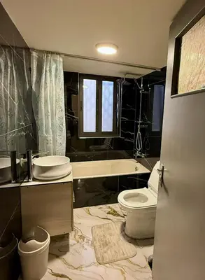 a bathroom with a toilet and a sink and a tub at Spacious central apartment in Amman