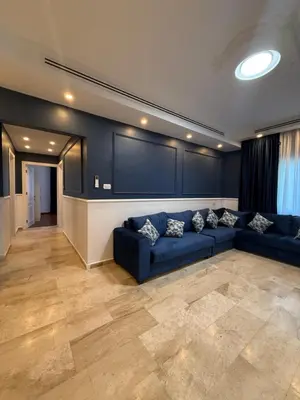 a living room with a blue couch and a wall at 3bedroom aprt of 200sqm near movenpick hotel amman in Amman