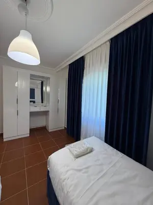 a bedroom with a large bed with blue curtains at 3bedroom aprt of 200sqm near movenpick hotel amman in Amman