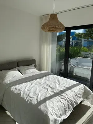 a bedroom with a white bed and a large window at Ayla-Azure in Aqaba