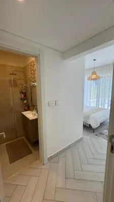 a bathroom with a shower and a bedroom with a bed at Ayla-Azure in Aqaba