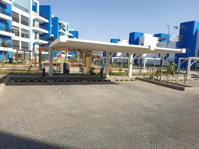 a bus stop in a parking lot in front of a building at Ayla-Azure in Aqaba
