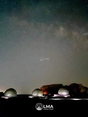 a group of people looking at the night sky at LMA Rum Luxury Camp in Wadi Rum