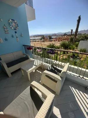 a patio with a couch and chairs on a balcony at شقه شاطئيه in Aqaba