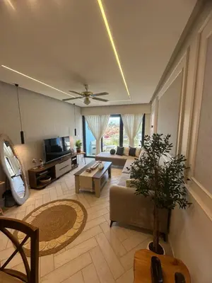 a living room with a couch and a tv at شقه شاطئيه in Aqaba